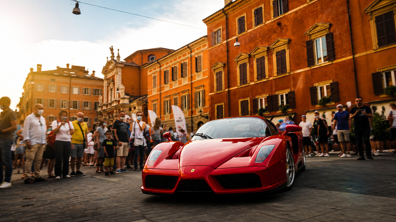 Roter Ferrari-Sportwagen vor historischen Gebäuden, umgeben von zuschauenden Menschen bei Sonnenuntergang.