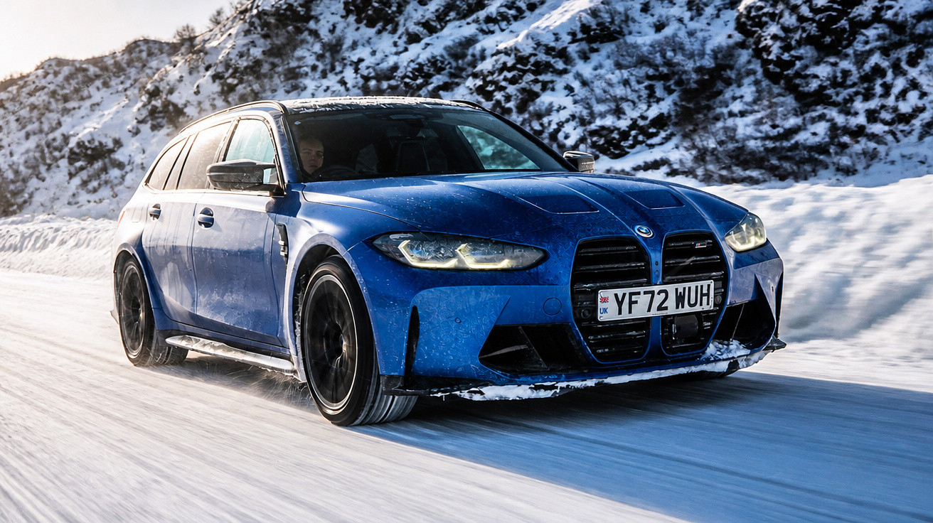 Blauer BMW Kombi fährt auf verschneiter Straße mit Schneebergen im Hintergrund.
